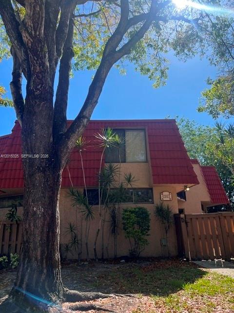 A two-story building with a red tiled roof and tan stucco exterior stands behind trees — 8129 Severn Dr # C, Boca Raton FL 33433, BOCA RATON, FL