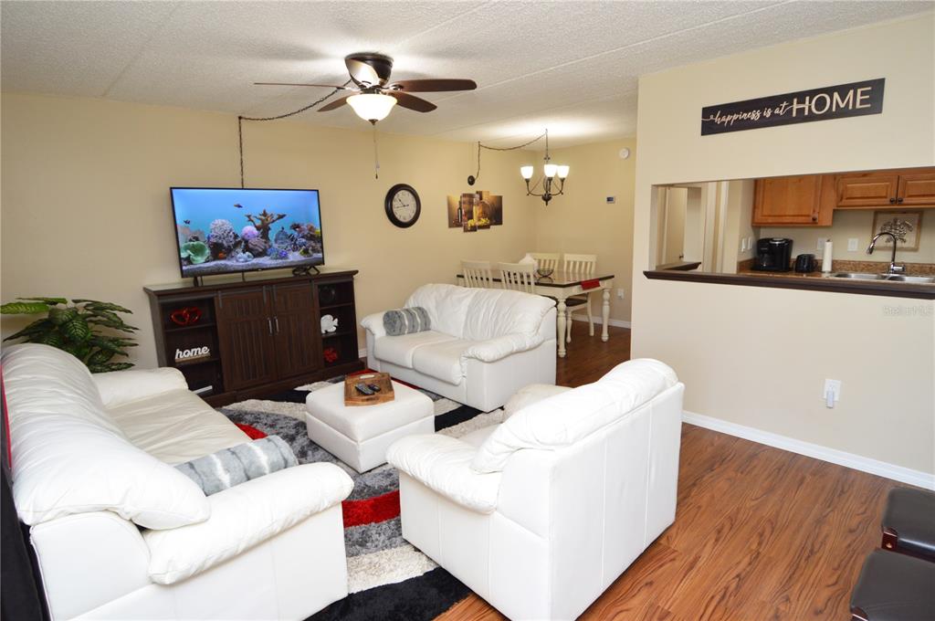 An exterior walkway with a white door leads to a multi-story apartment building with balconies — 12760 INDIAN ROCKS ROAD UNIT 1030 (Furnished), LARGO, FL