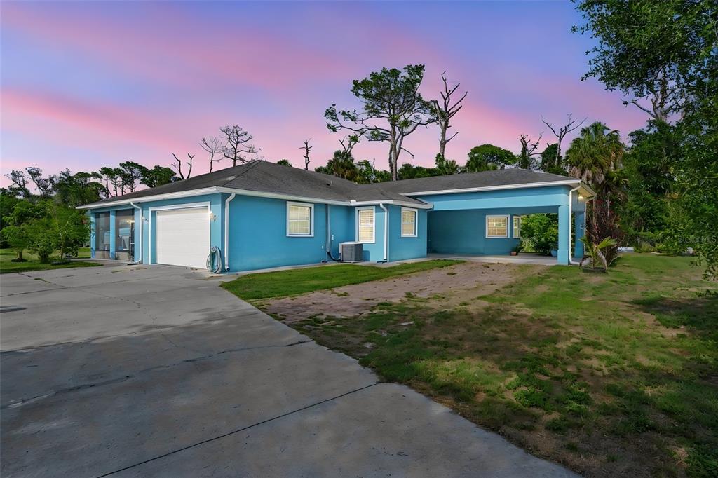 A bright blue house features a two-car garage, a carport, and a concrete driveway — 2007 61ST STREET, SARASOTA, FL