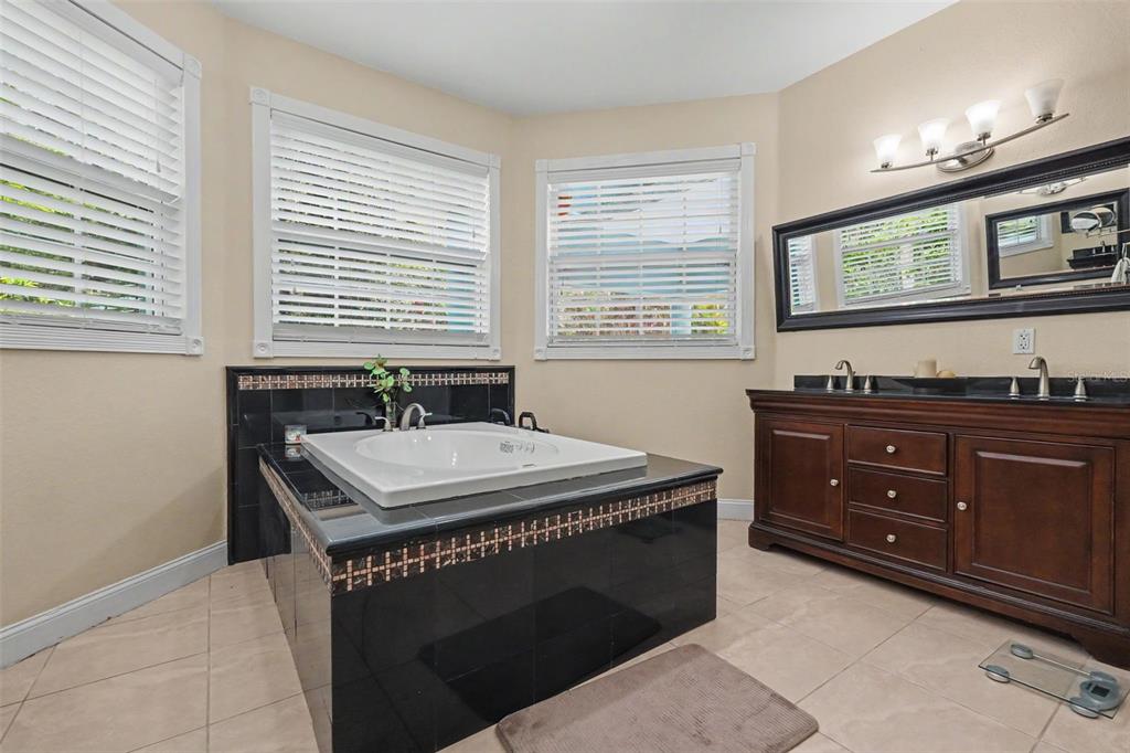 A living room features white marble flooring, two tan sofas, and a ceiling fan — 2007 61ST STREET, SARASOTA, FL