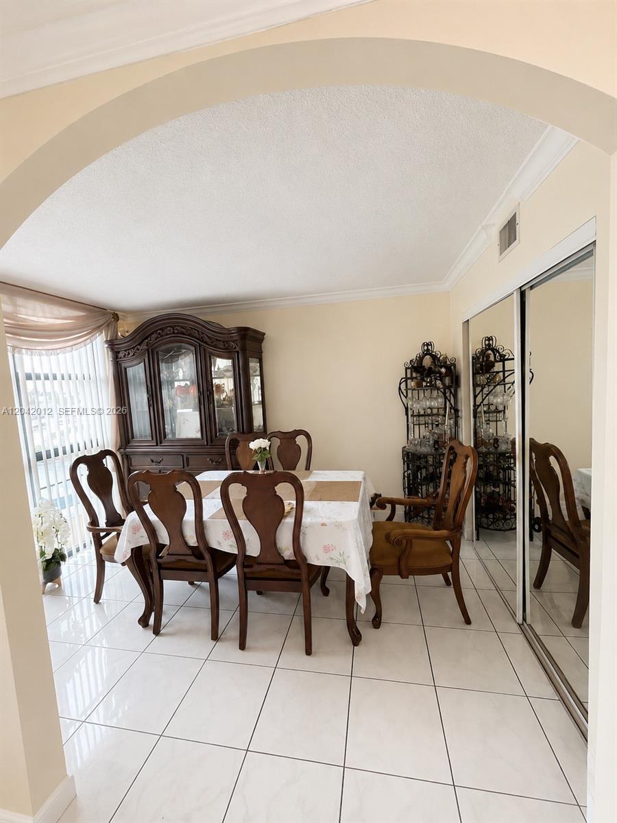 A dining room features a dark wood hutch, a table with six chairs, and mirrored closets — 2055 SW 122nd Ave # 321, Miami FL 33175, MIAMI, FL