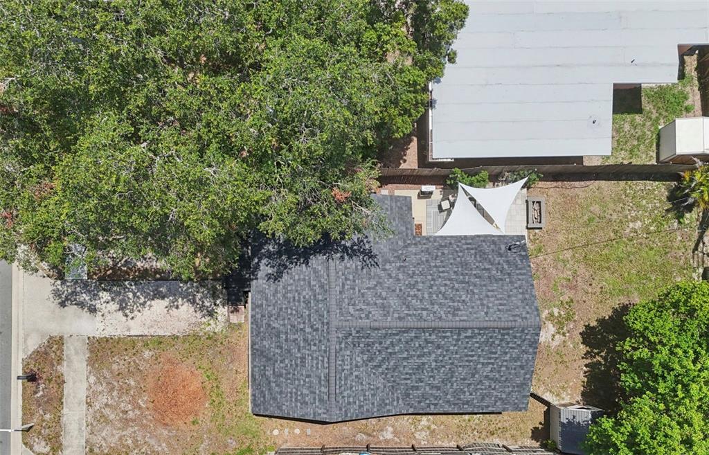 An aerial view shows a house with a dark shingled roof, a large tree, and patio — 4924 45TH AVENUE N, ST PETERSBURG, FL