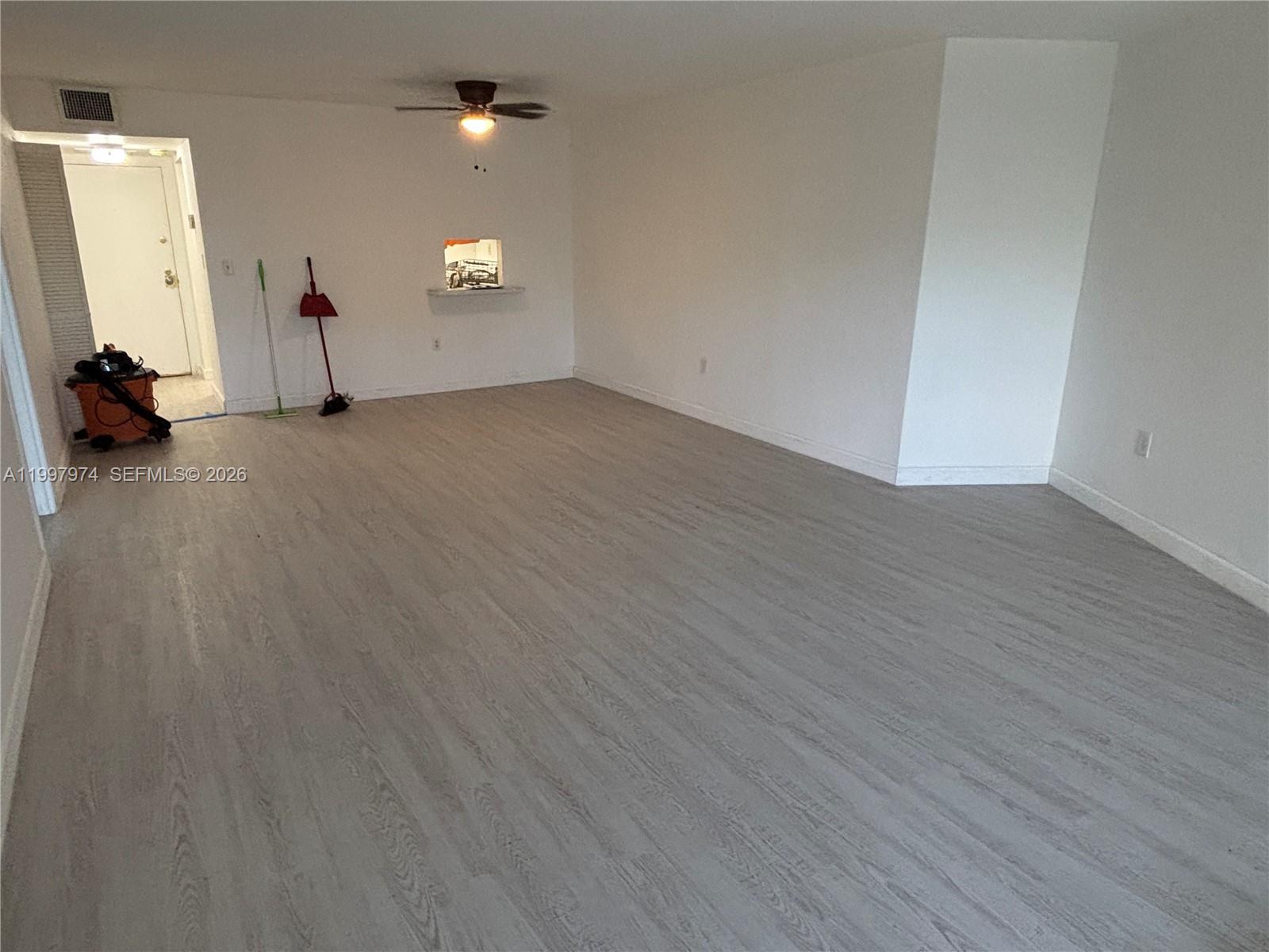 An empty room features light-colored wood-look flooring, white walls, and a ceiling fan — 10854 N KENDALL DR # 316, Miami FL 33176, MIAMI, FL