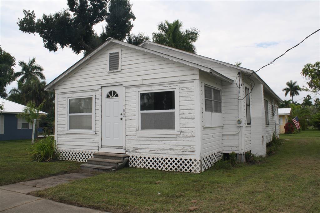 A small, white, single-story house with wood siding and a lattice-covered foundation — 702 W OLYMPIA AVENUE, PUNTA GORDA, FL