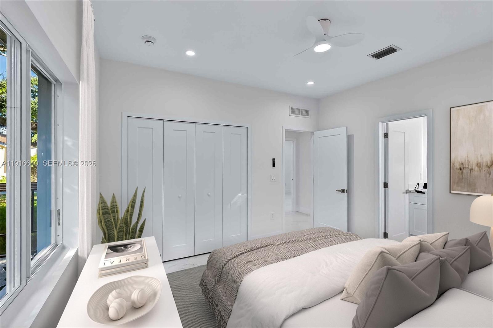 A modern bedroom features white walls, a bed, a closet, and an attached bathroom — 1346 NW 44th St, Miami FL 33142, MIAMI, FL