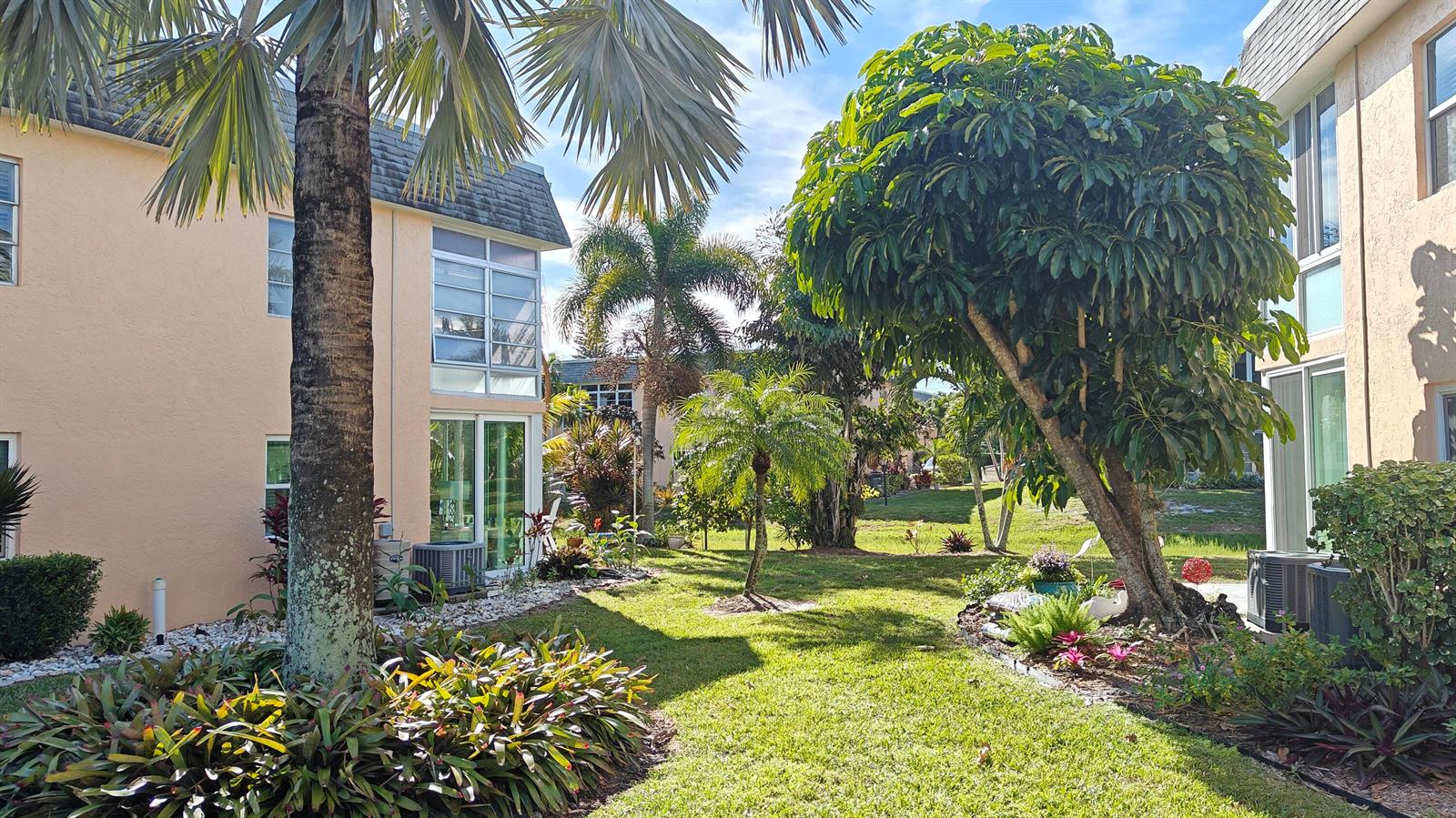 A grassy courtyard between two multi-story apartment buildings with palm trees and landscaping — 2950 SE Ocean Boulevard # 6, Stuart FL 34996, STUART, FL