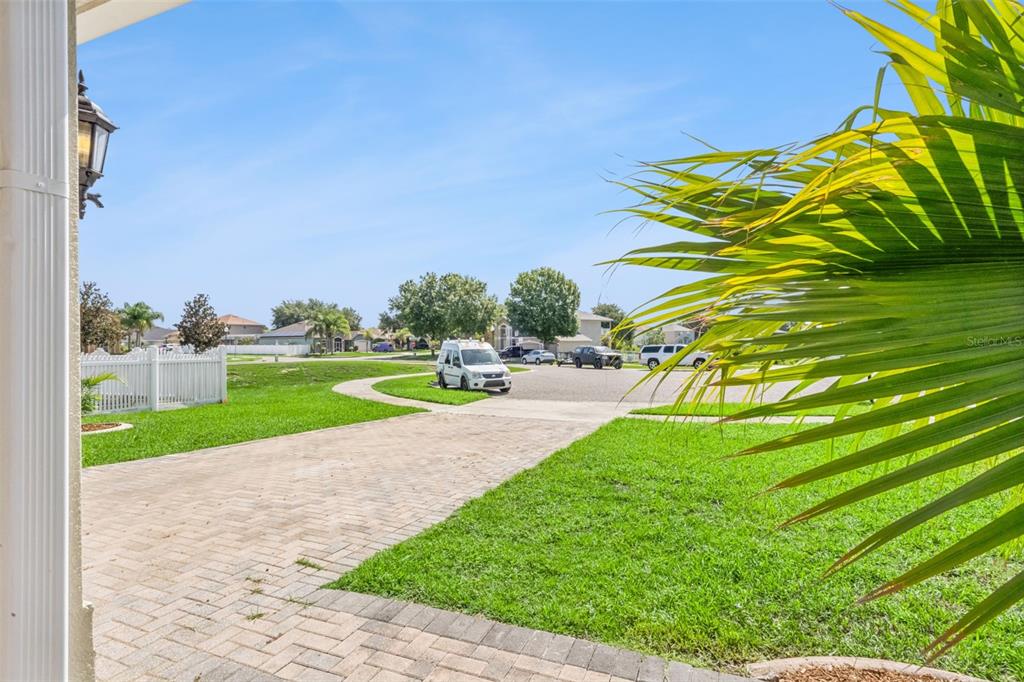 A view from a porch looking out over a paved driveway, lawn, and suburban street — 15507 MARBLEHEAD WAY, CLERMONT, FL