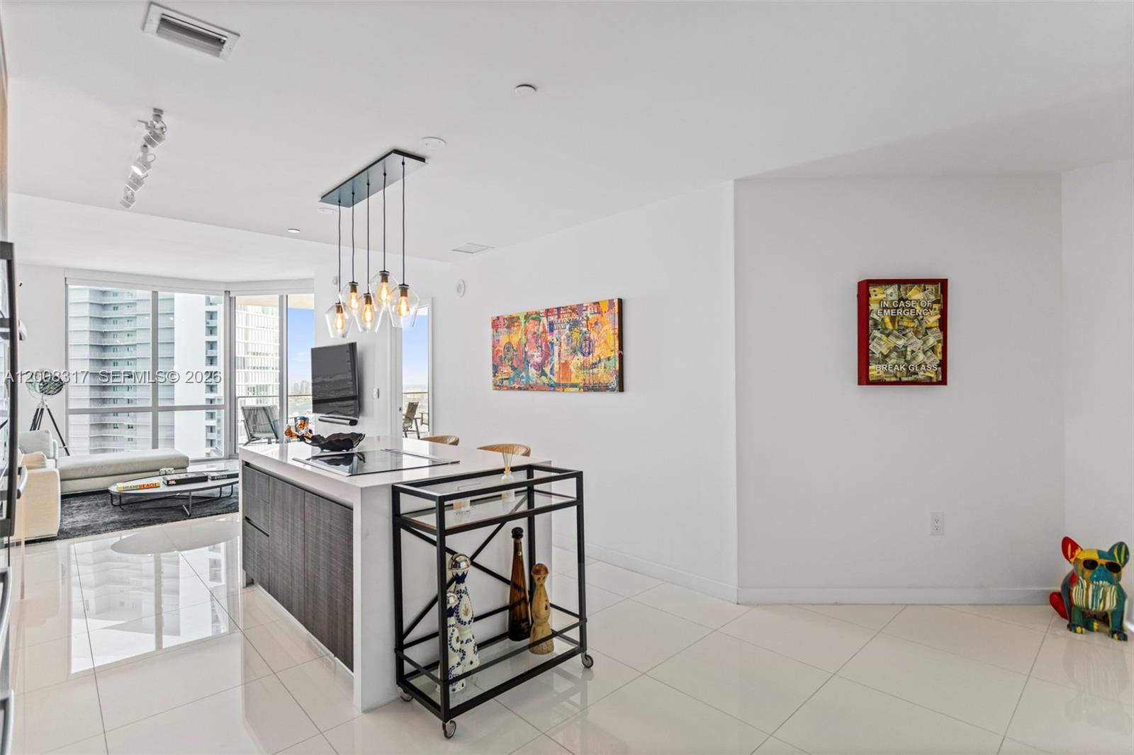 A modern kitchen island with a bar cart sits in a bright, open-concept living space — 851 NE 1st Ave # 3707, Miami FL 33132, MIAMI, FL