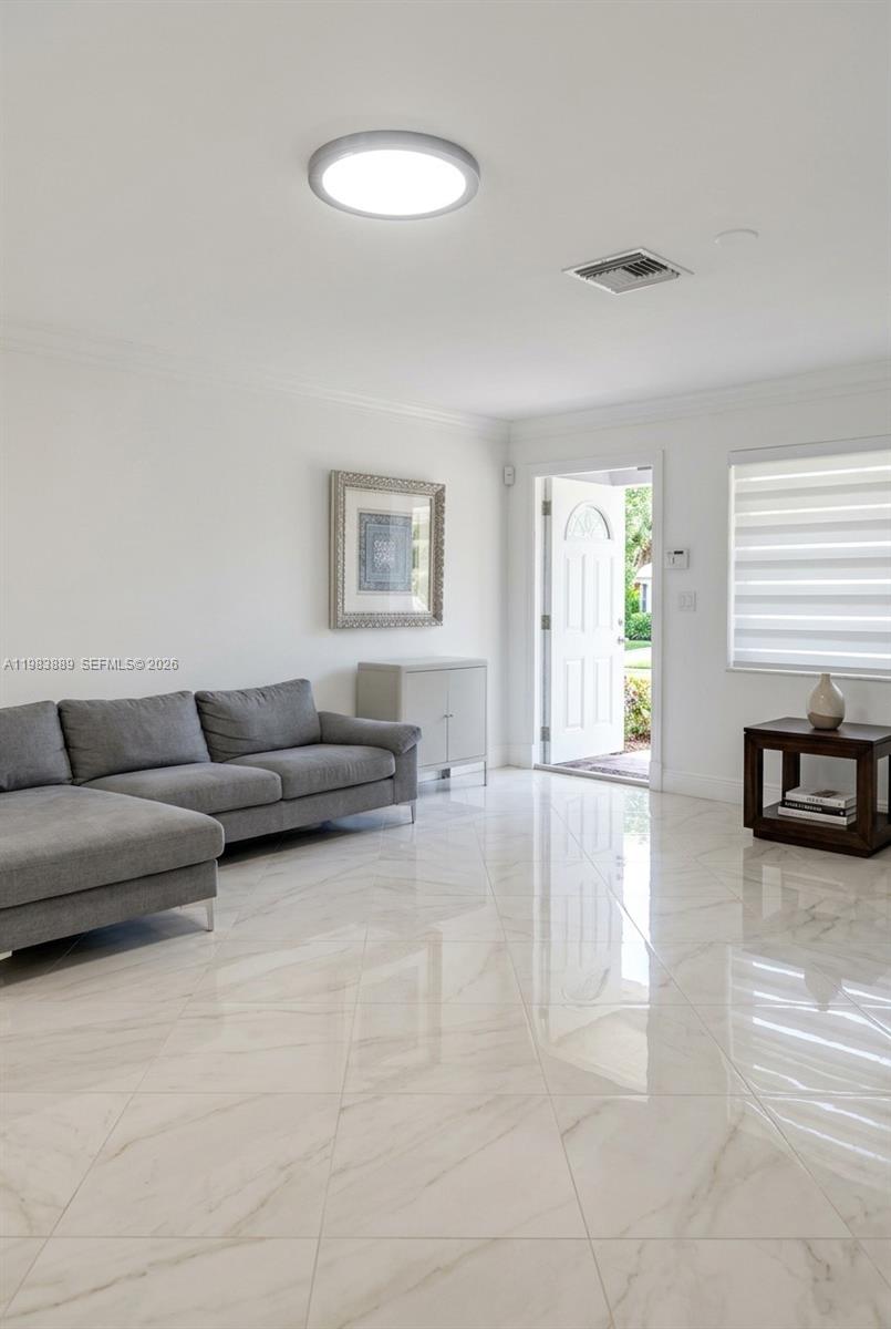 A living room features a gray sectional sofa, white marble-look tile floors, and an open door — 804 NE 2nd St, Hallandale Beach FL 33009, HALLANDALE BEACH, FL