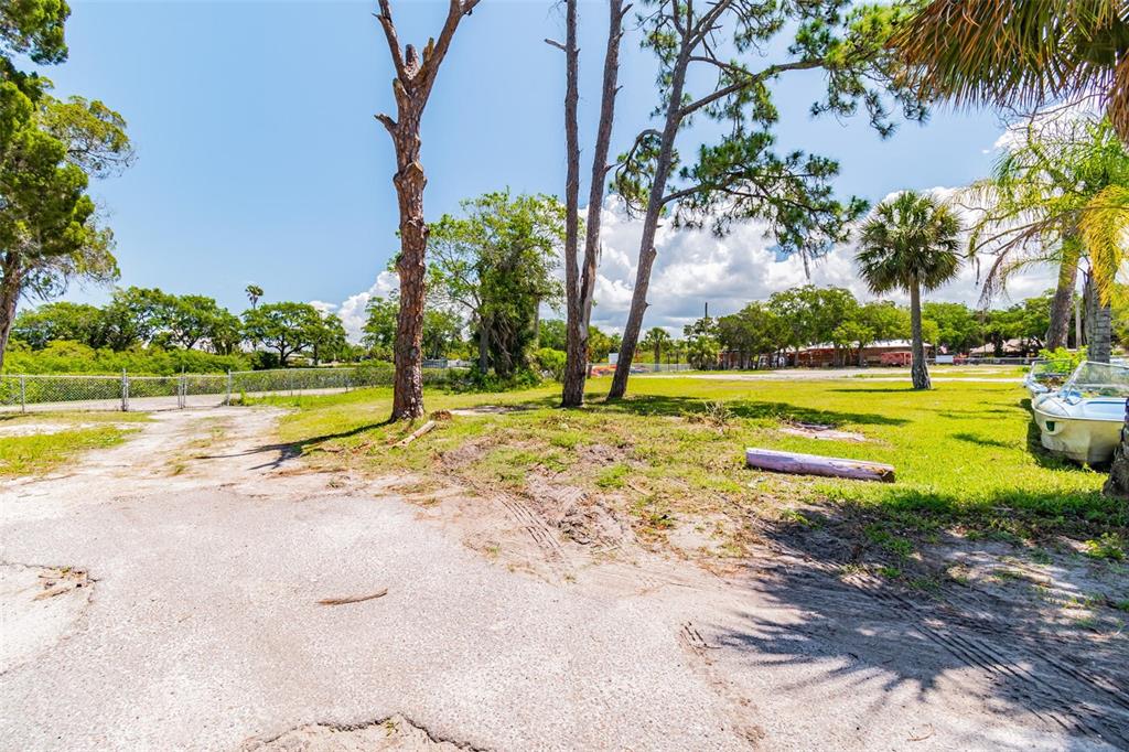 A dirt and gravel driveway leads to a grassy lot with trees and a boat — 5325 TREADWAY DRIVE, PORT RICHEY, FL
