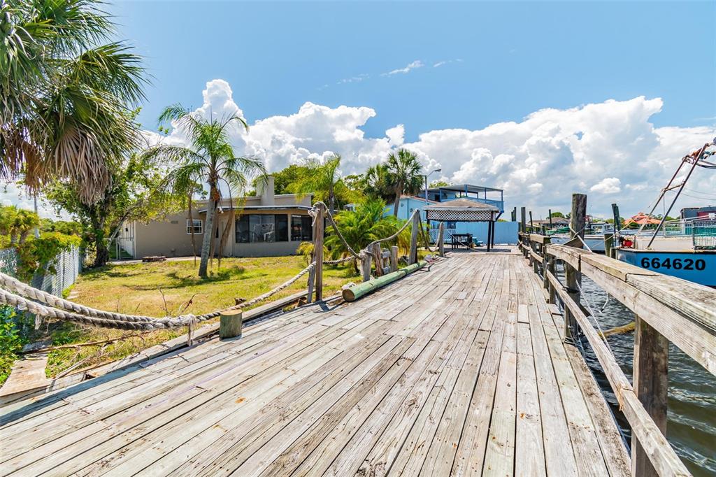A wooden dock extends toward a house and a gazebo along a waterfront — 5325 TREADWAY DRIVE, PORT RICHEY, FL