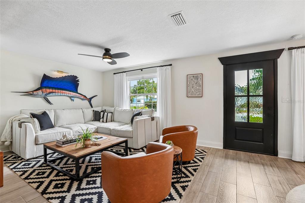 A living room features a sectional sofa, two leather chairs, a patterned rug, and a marlin — 472 36TH AVENUE N, ST PETERSBURG, FL