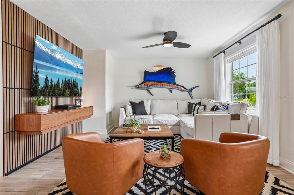 A living room features a wood-slat accent wall, a wall-mounted television, and a sailfish mount — 472 36TH AVENUE N, ST PETERSBURG, FL