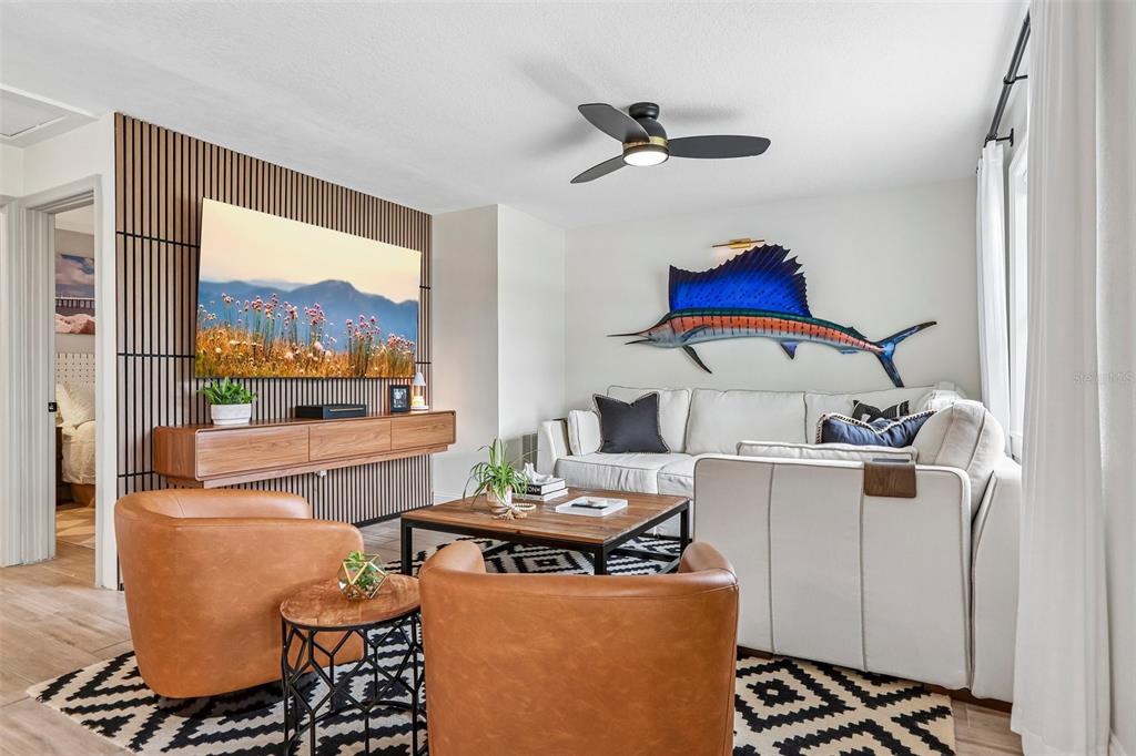 A living room features a slatted wood accent wall, a sailfish wall mount, and leather chairs — 472 36TH AVENUE N, ST PETERSBURG, FL