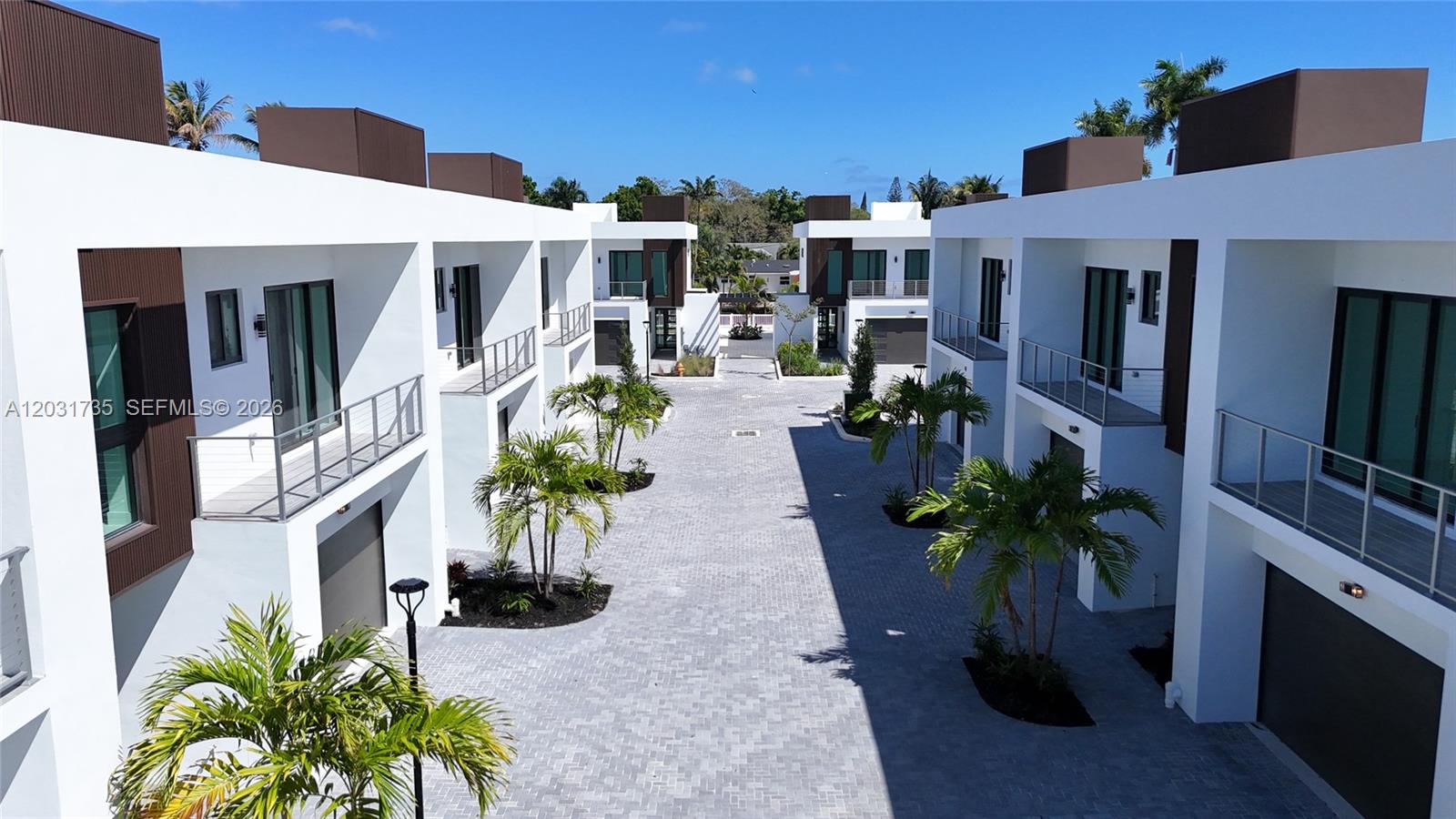 An exterior view of a modern townhouse complex with a paved courtyard and palm trees — 4624 SW 32nd Ave # A3, Dania Beach FL 33312, DANIA BEACH, FL