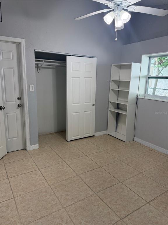 A room with tiled floors, a ceiling fan, a closet, and a white bookshelf — 7325 IVANHOE DRIVE, PORT RICHEY, FL