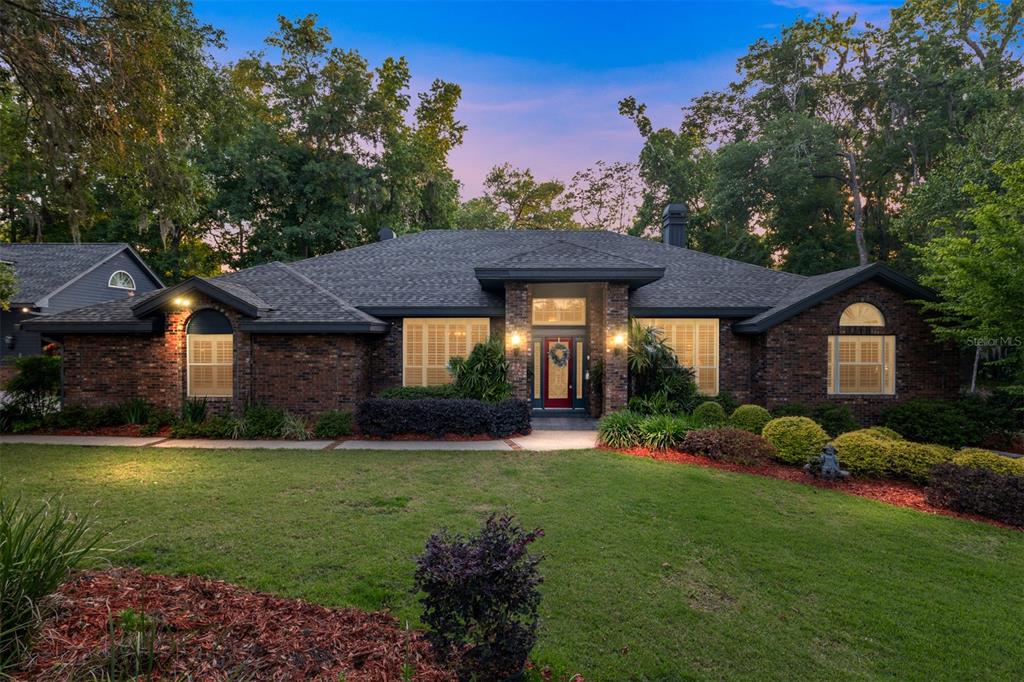 A collage of a house exterior featuring a stone patio, fire pit, hot tub, and landscaping — 2512 NW 58TH BOULEVARD, GAINESVILLE, FL