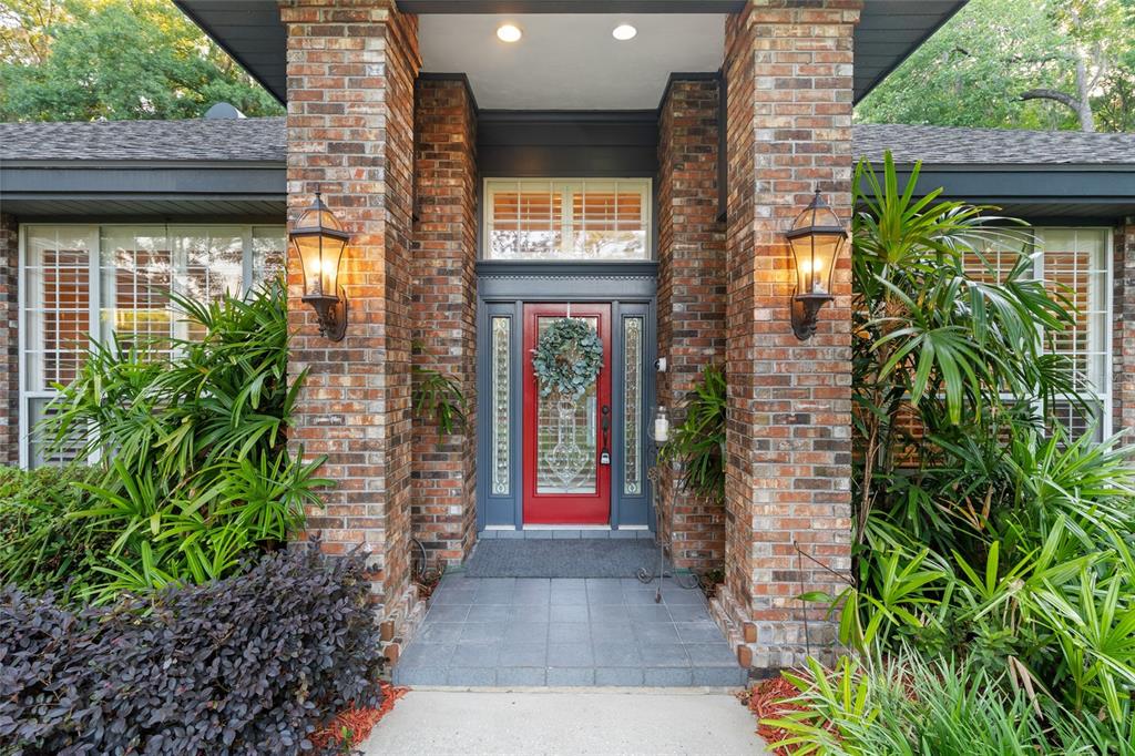 A single-story brick house with a gray shingled roof and a red front door — 2512 NW 58TH BOULEVARD, GAINESVILLE, FL