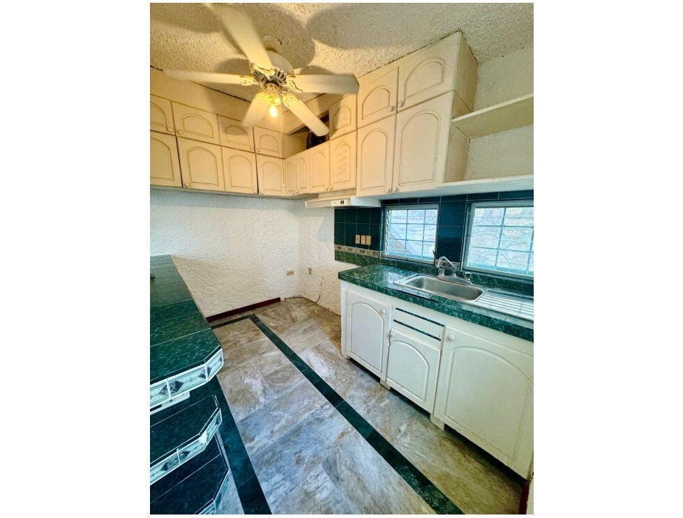A kitchen features white cabinets, green tiled countertops, a ceiling fan, and marble-style flooring — . Calle Antilope No. 14 # 20, FL