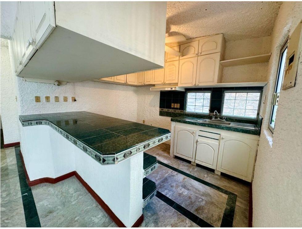 A kitchen features white cabinets, green tiled countertops, and a matching tiled breakfast bar — . Calle Antilope No. 14 # 20, FL