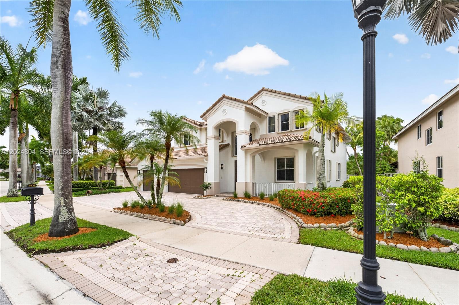A two-story house with a paved driveway, palm trees, and a tiled roof — 2432 Deer Creek Rd, Weston FL 33327, WESTON, FL