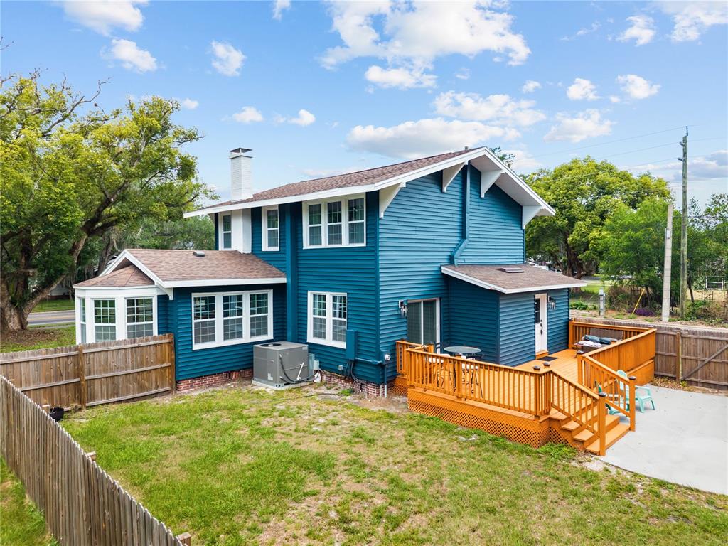 A two-story blue house with a wooden deck and fenced backyard under a cloudy sky — 2001 SANFORD AVENUE, SANFORD, FL