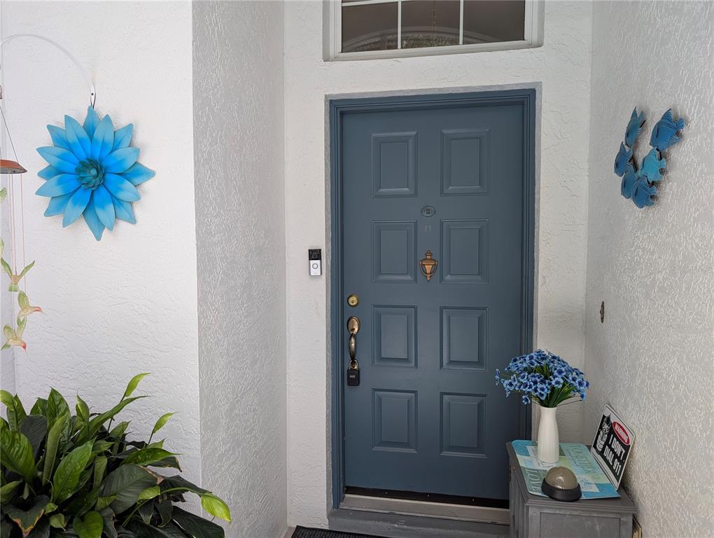 A blue front door with a brass knocker and a doorbell camera on a porch — 4286 N MAE WEST WAY, BEVERLY HILLS, FL