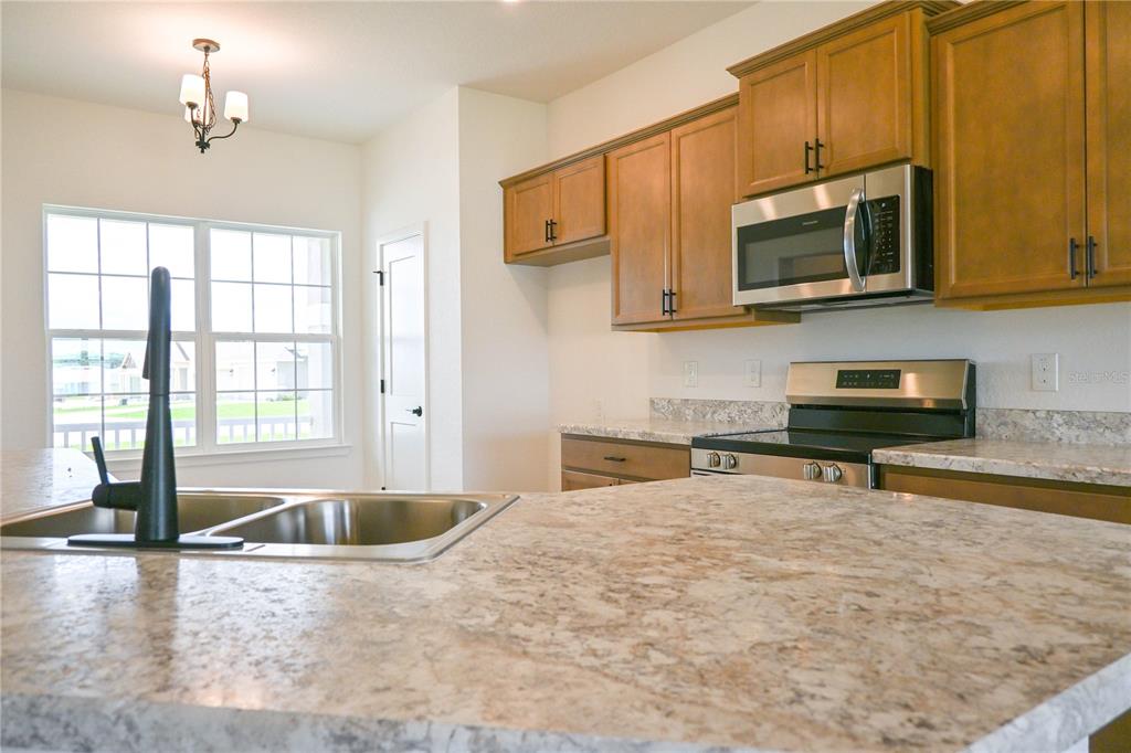 An open living area features light-colored tile flooring, white walls, and a carpeted staircase — 3151 NE 45TH AVENUE, OCALA, FL