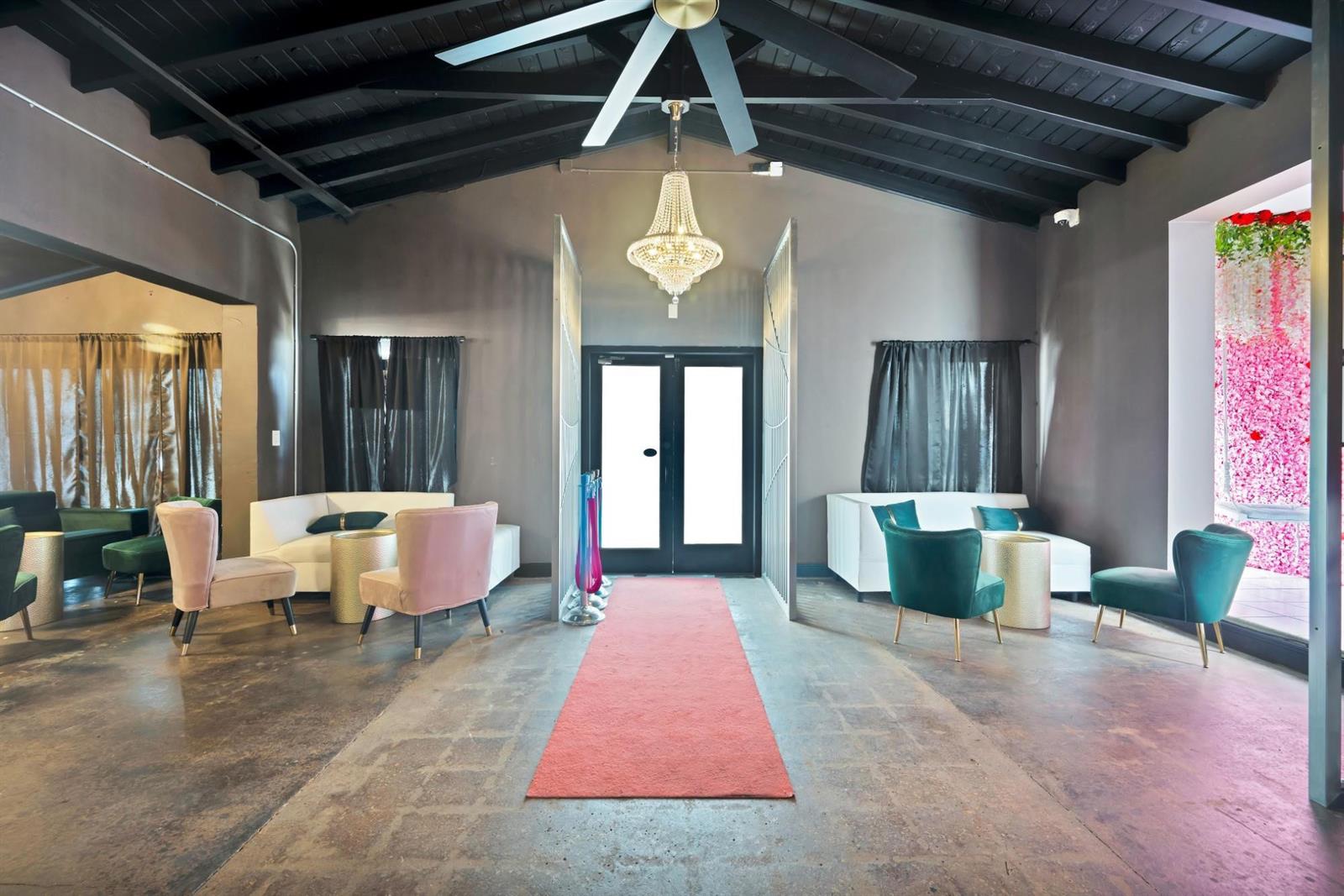 A lounge area features a red carpet runner, a crystal chandelier, and velvet accent chairs — FORT LAUDERDALE, FL