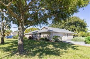 A single-story house with a light-colored exterior, a garage, and a large tree in front — 5740 36th Place, Vero Beach FL 32966, VERO BEACH, FL