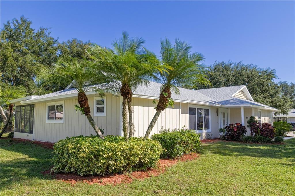 A single-story house with light-colored vertical siding, a gray roof, and two prominent palm trees — 5740 36th Place, Vero Beach FL 32966, VERO BEACH, FL