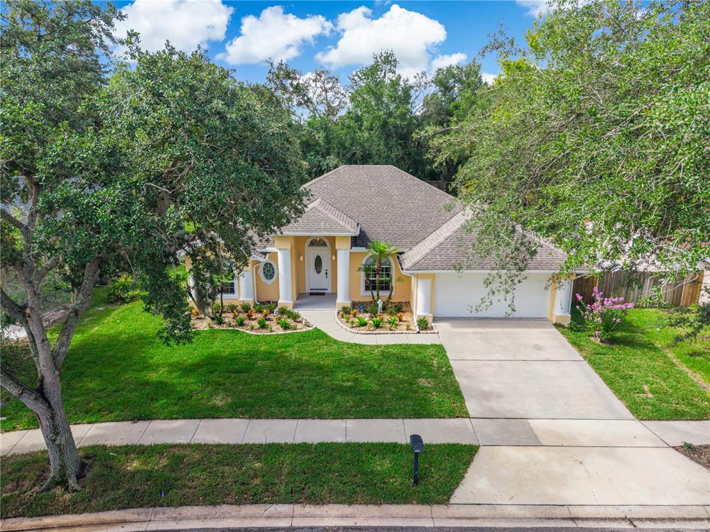 A single-story yellow house with a white front door, columns, and a two-car garage — 2672 LAKE JACKSON CIRCLE, APOPKA, FL