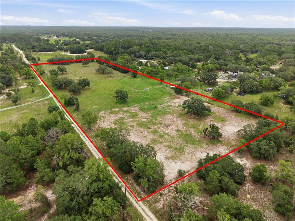 An aerial view shows a large, rectangular plot of land outlined in red — 7291 S WANDERLUST POINT, HOMOSASSA, FL
