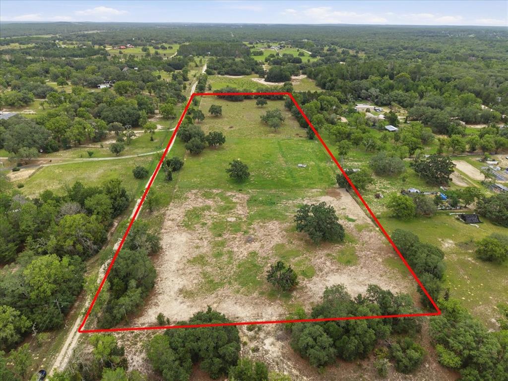 An aerial view shows a rectangular plot of land outlined in red with scattered trees — 7291 S WANDERLUST POINT, HOMOSASSA, FL