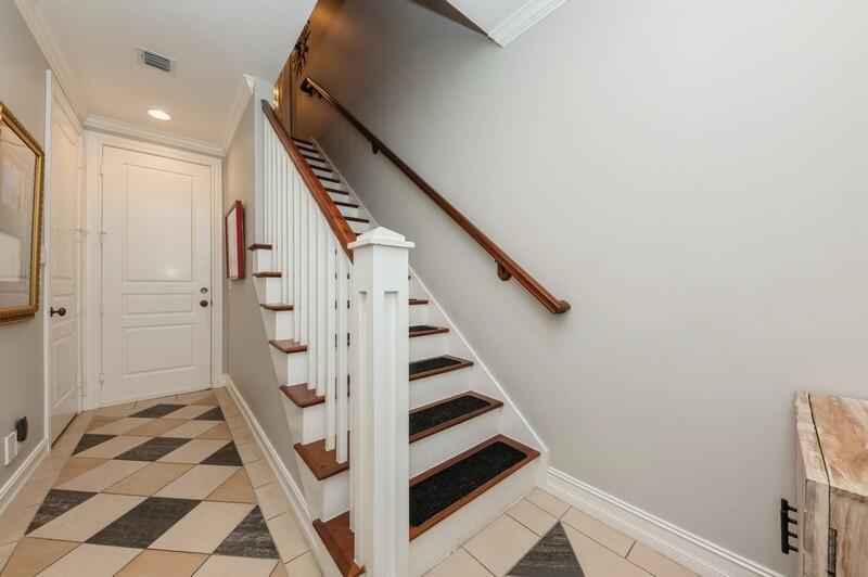 An entryway features a staircase with wooden treads, white railings, and a patterned tile floor — 310 E Mallory Circle, Delray Beach FL 33483, DELRAY BEACH, FL
