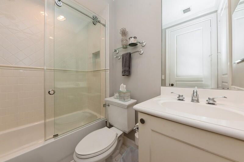A bathroom features a white vanity, a toilet, and a glass-enclosed shower-tub combination — 310 E Mallory Circle, Delray Beach FL 33483, DELRAY BEACH, FL