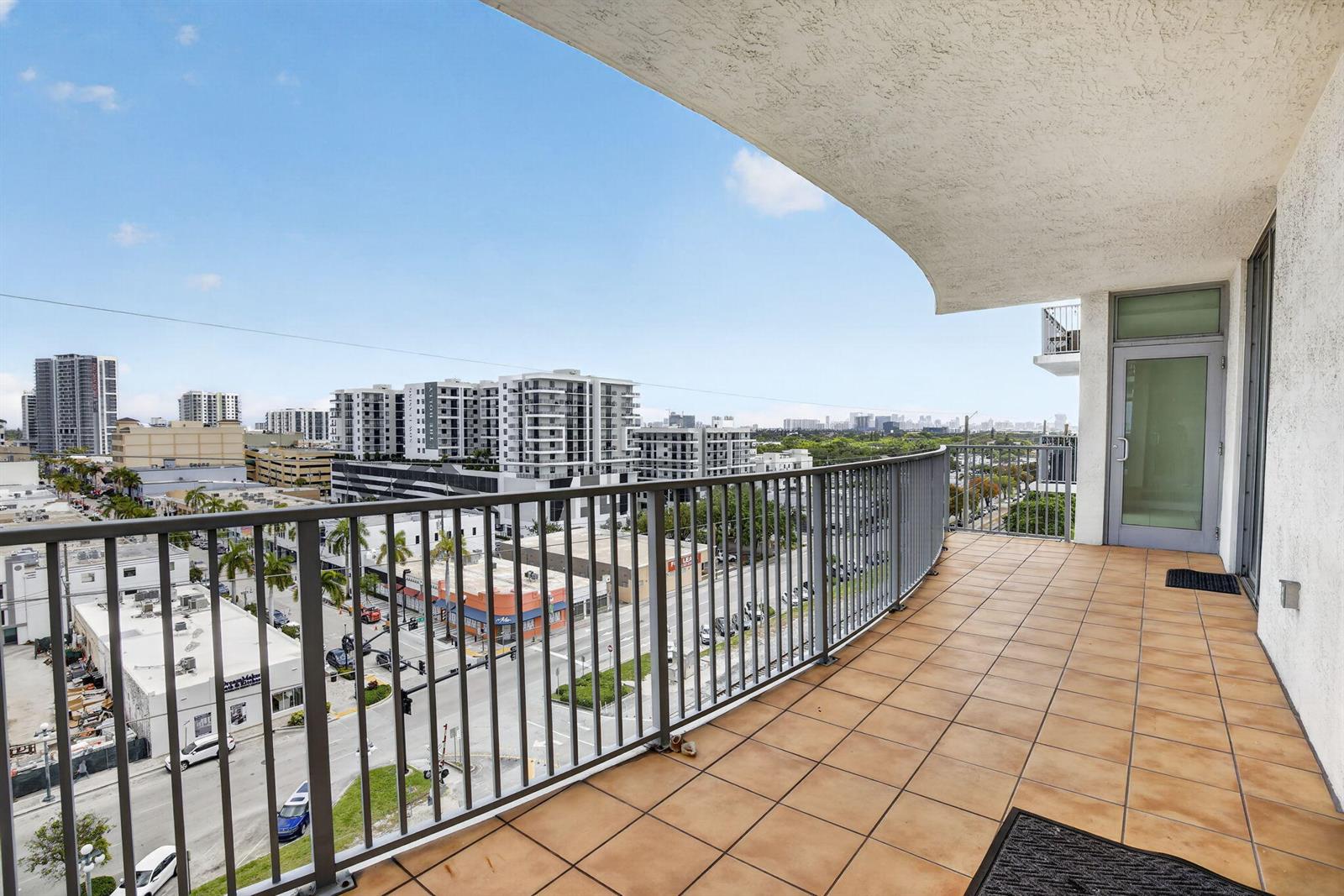 A tiled balcony with a metal railing overlooks a city street and surrounding buildings — 140 S Dixie Highway # 819, Hollywood FL 33020, HOLLYWOOD, FL