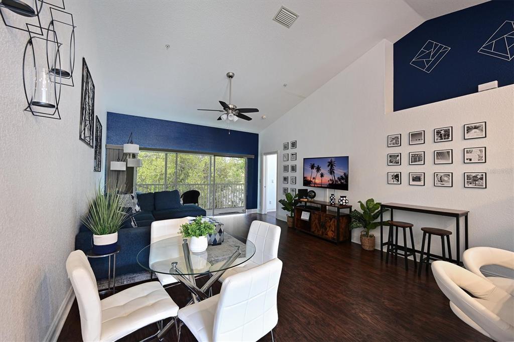 A living and dining area with white walls, blue accent walls, and dark wood flooring — 6589 FAIRWAY GARDENS DRIVE UNIT 202, BRADENTON, FL