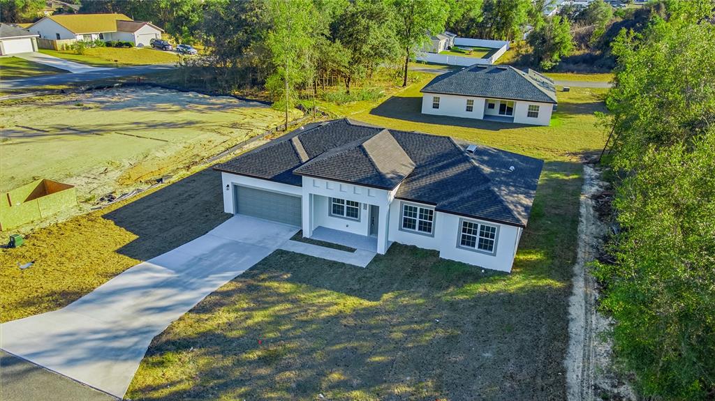 An aerial view of a newly constructed single-story house with a gray roof and driveway — 13690 SW 43RD CIRCLE, OCALA, FL