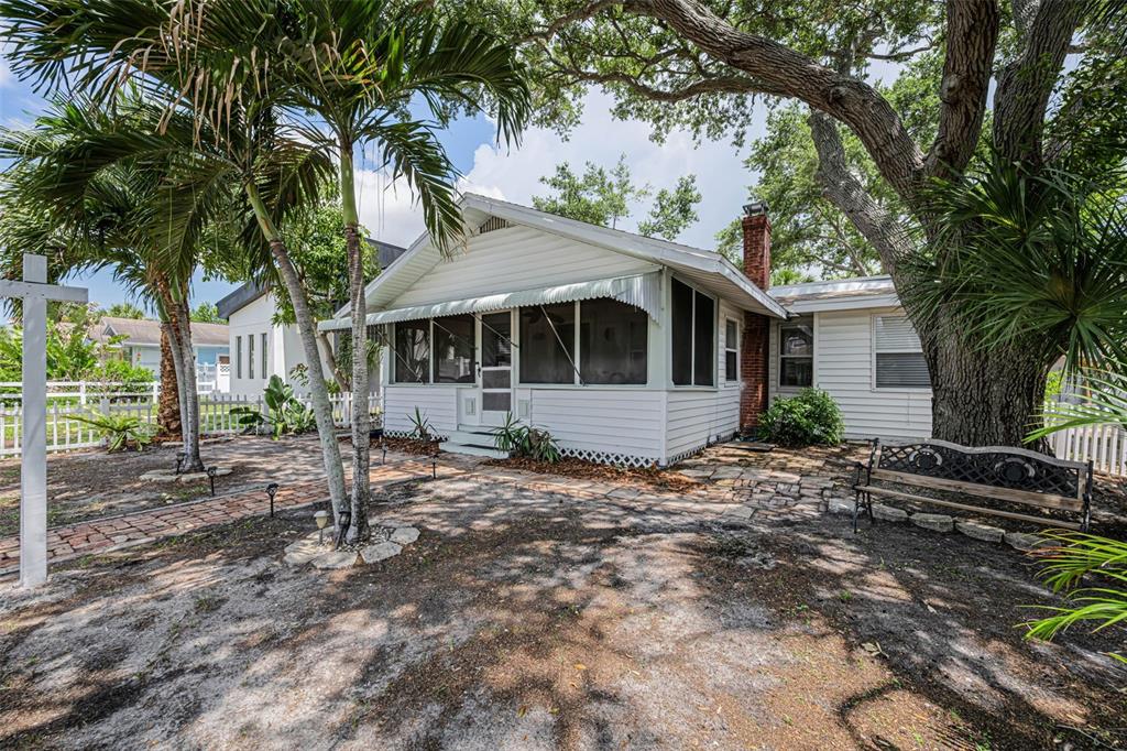 A white cottage with a screened porch, brick chimney, and palm trees in the yard — 3829 2ND AVENUE N, ST PETERSBURG, FL