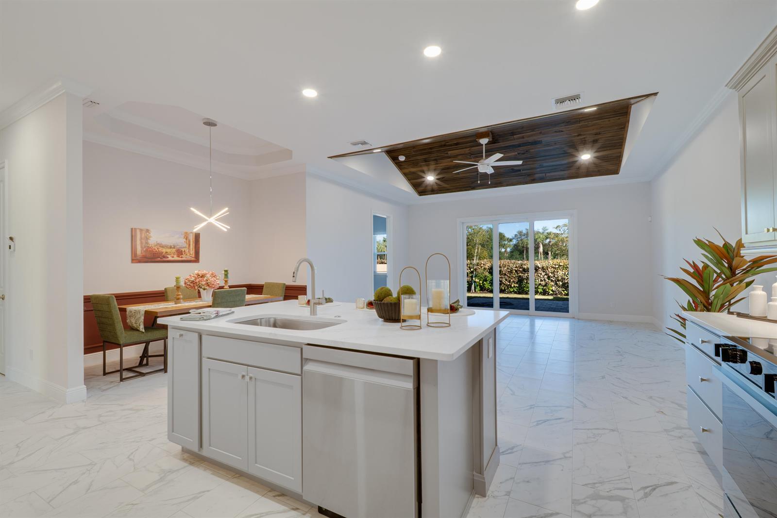 A kitchen island with a white countertop sits in a room with marble-look tile flooring — 1805 Bridgepointe Circle # 2, Vero Beach FL 32967, VERO BEACH, FL