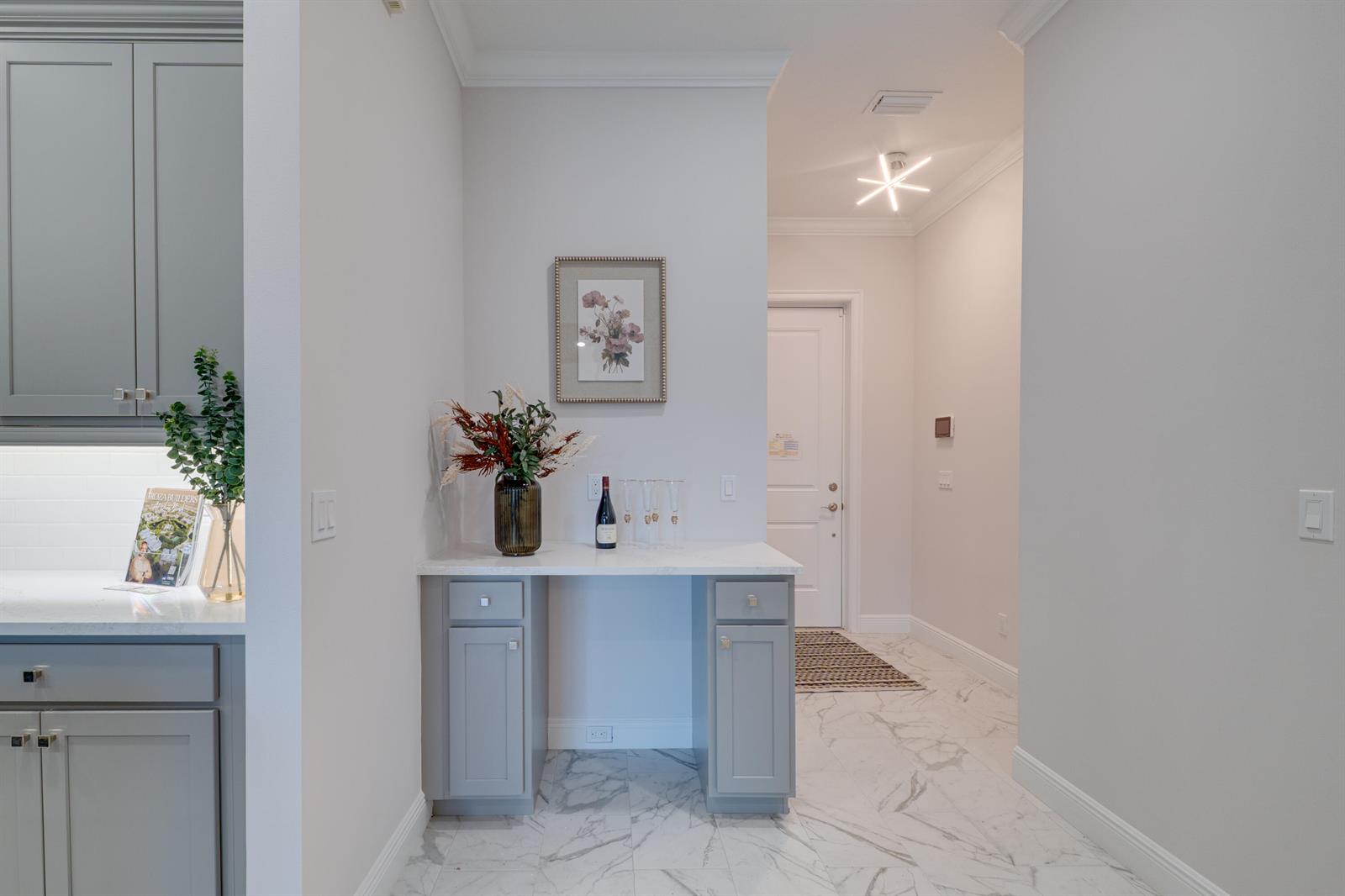 A gray cabinet console with a white countertop sits in a hallway with marble floors — 1805 Bridgepointe Circle # 2, Vero Beach FL 32967, VERO BEACH, FL