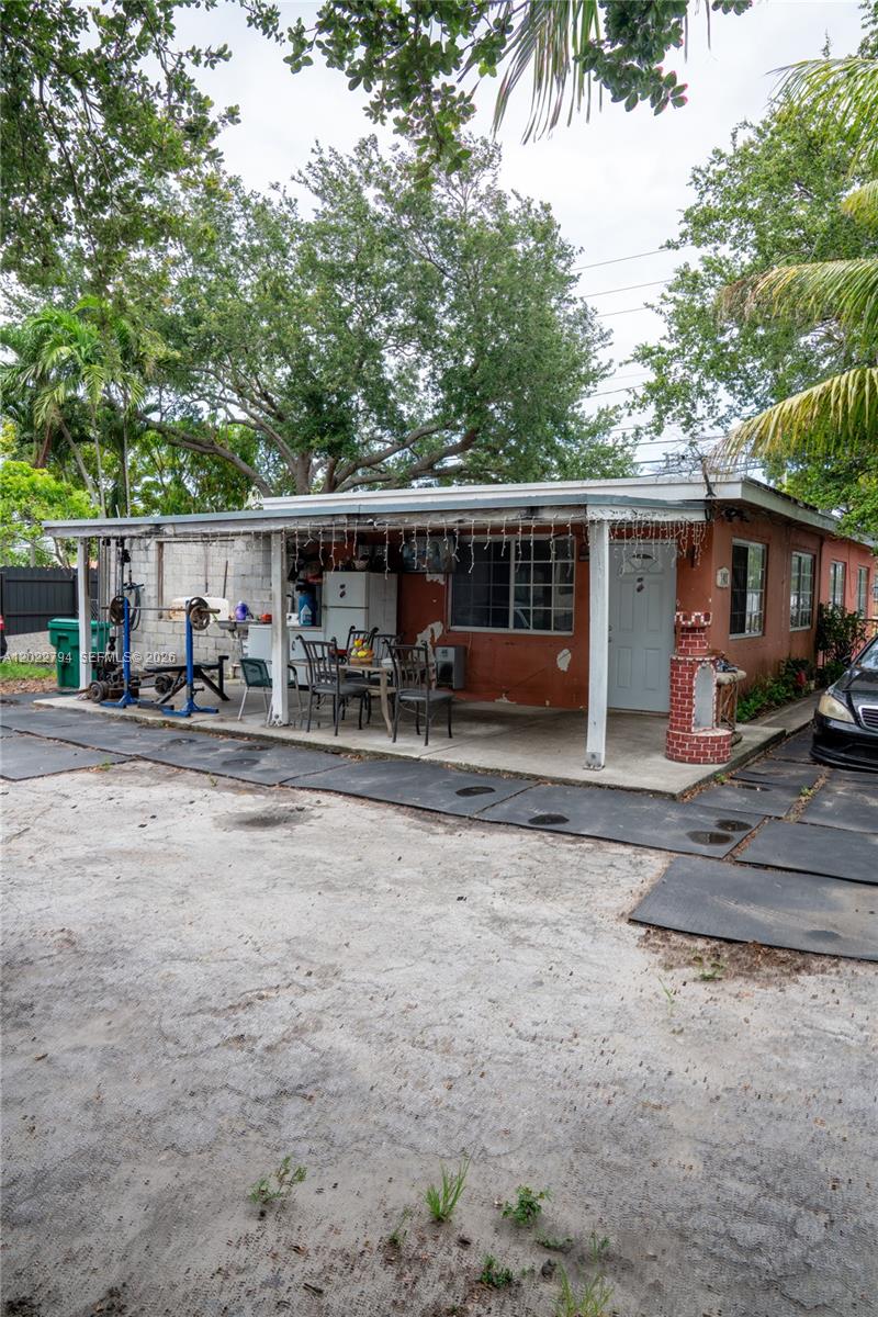 An exterior view of a house with a covered patio, outdoor gym equipment, and driveway — 3401 NW 15th St, Miami FL 33125, MIAMI, FL
