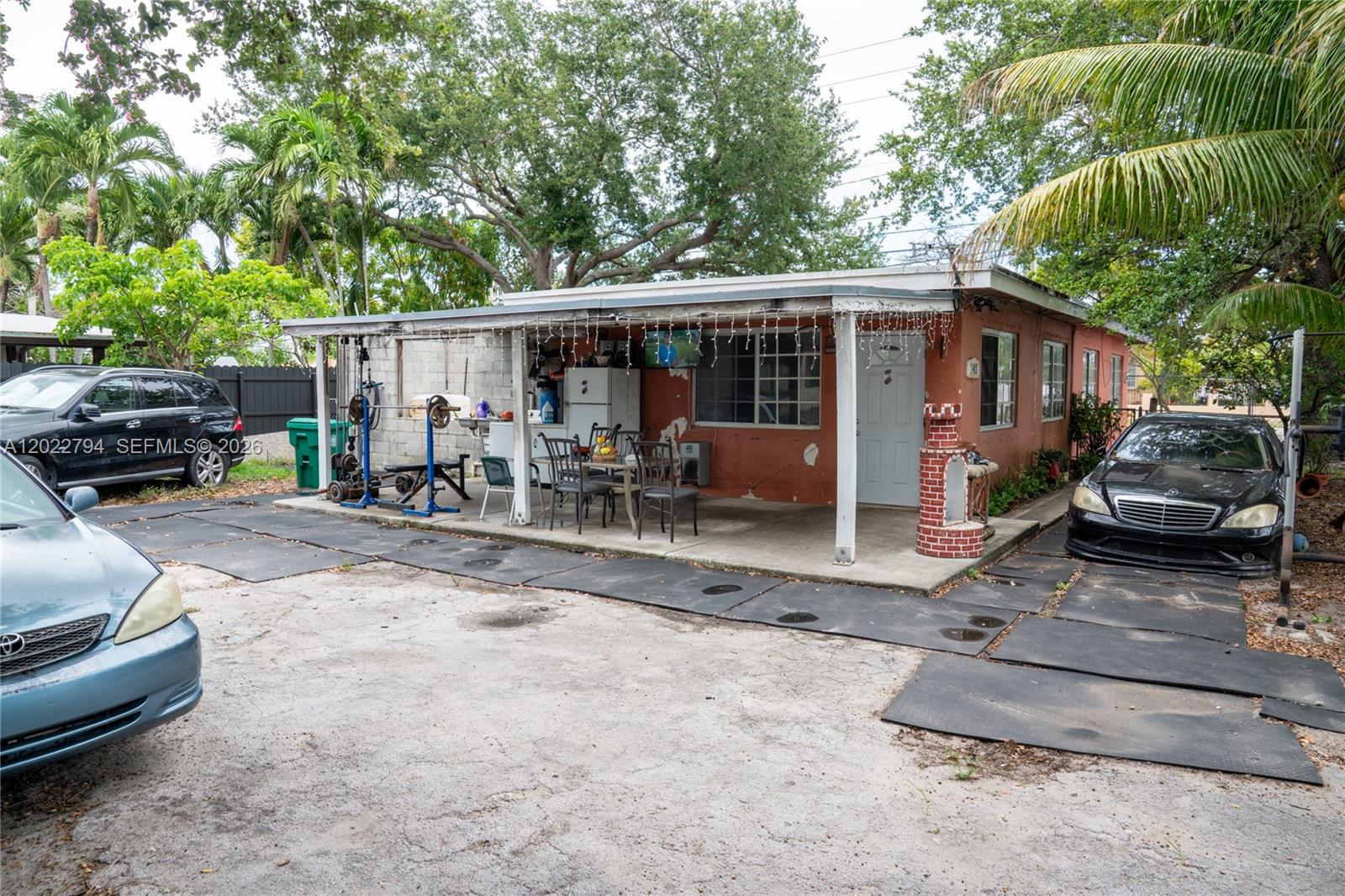 A single-story house with a covered patio, outdoor gym equipment, and parked cars — 3401 NW 15th St, Miami FL 33125, MIAMI, FL