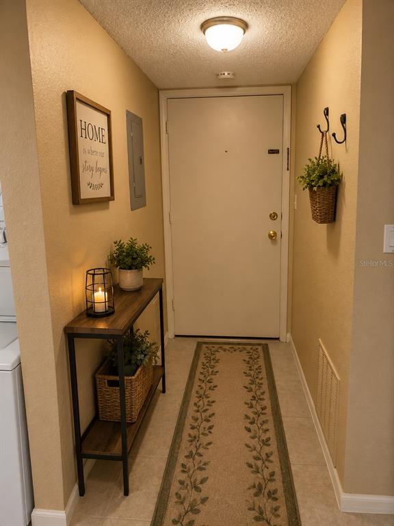 An entryway features a console table, a runner rug, and a wall-mounted basket with greenery — 3586 CAPE HAZE DRIVE UNIT B6, ROTONDA WEST, FL