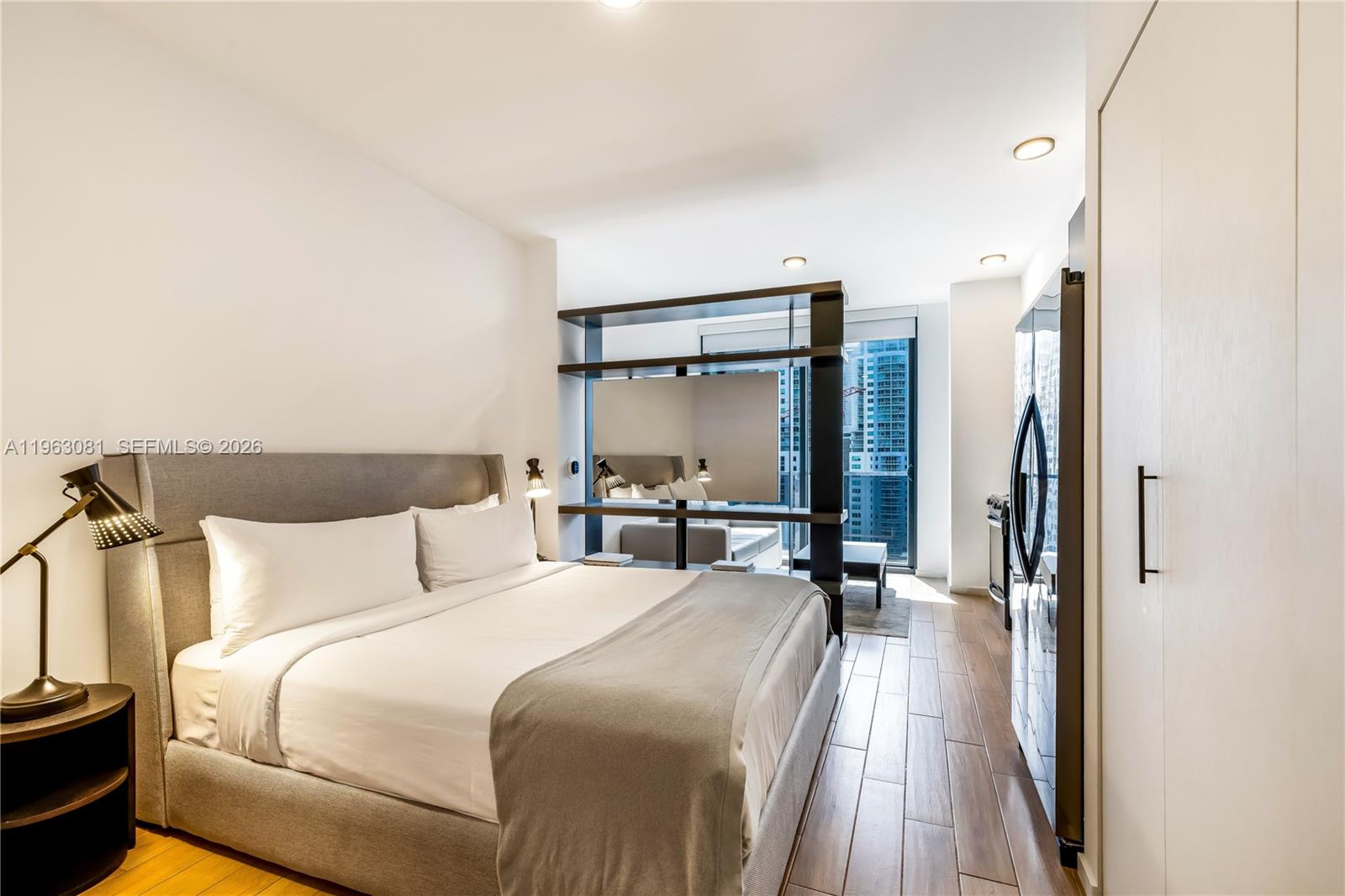 A modern studio apartment features a bed, a room divider, and a kitchenette — 398 NE 5th St # 2116, Miami FL 33132, MIAMI, FL