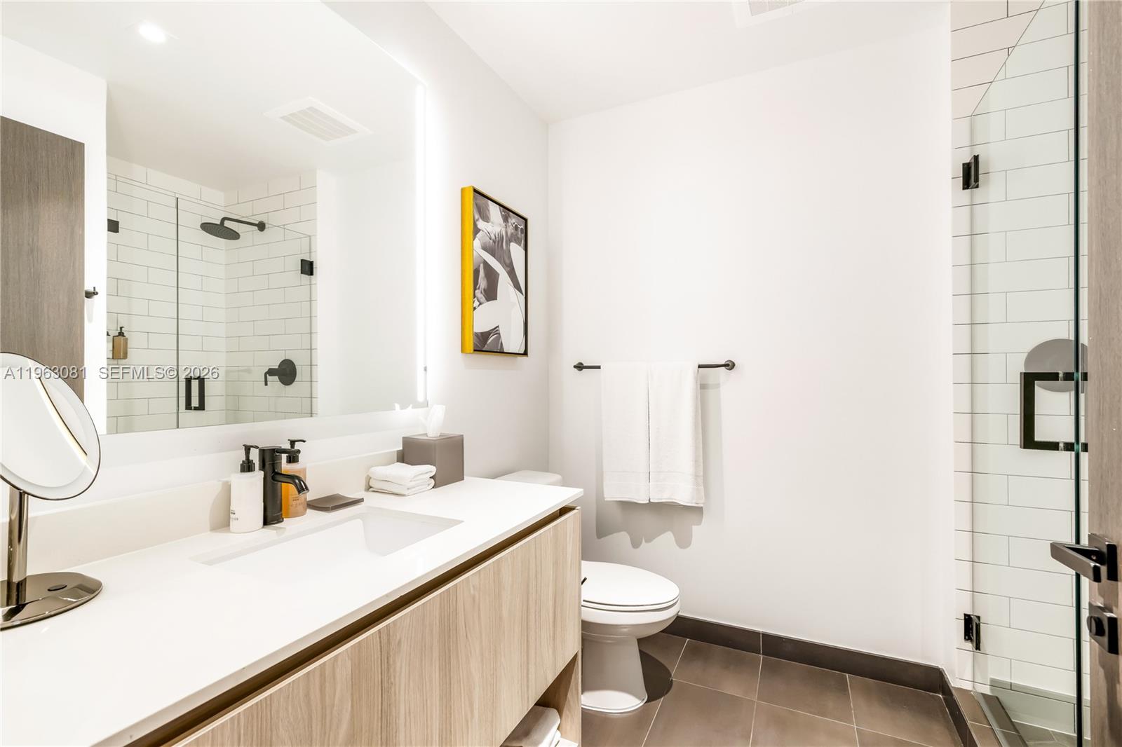 A modern bathroom features a wood vanity, white countertop, walk-in shower, and a toilet — 398 NE 5th St # 2116, Miami FL 33132, MIAMI, FL