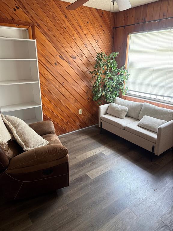 A room features wood-paneled walls, a white bookshelf, a brown recliner, and a light-colored sofa — 500 E 25TH STREET, SANFORD, FL