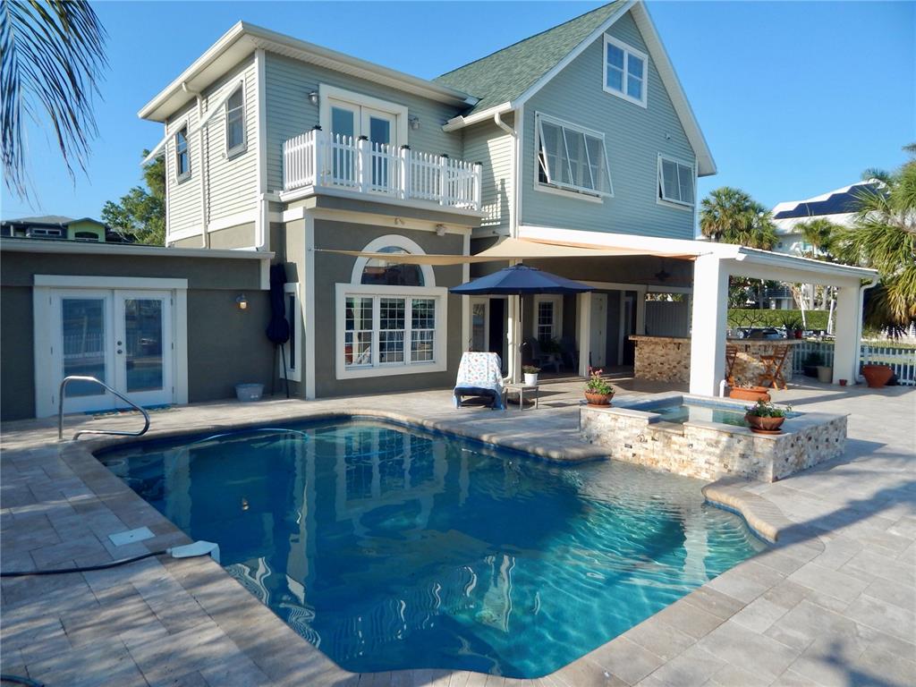 A two-story house with a swimming pool, hot tub, and covered patio area — 8025 ISLAND DRIVE, PORT RICHEY, FL