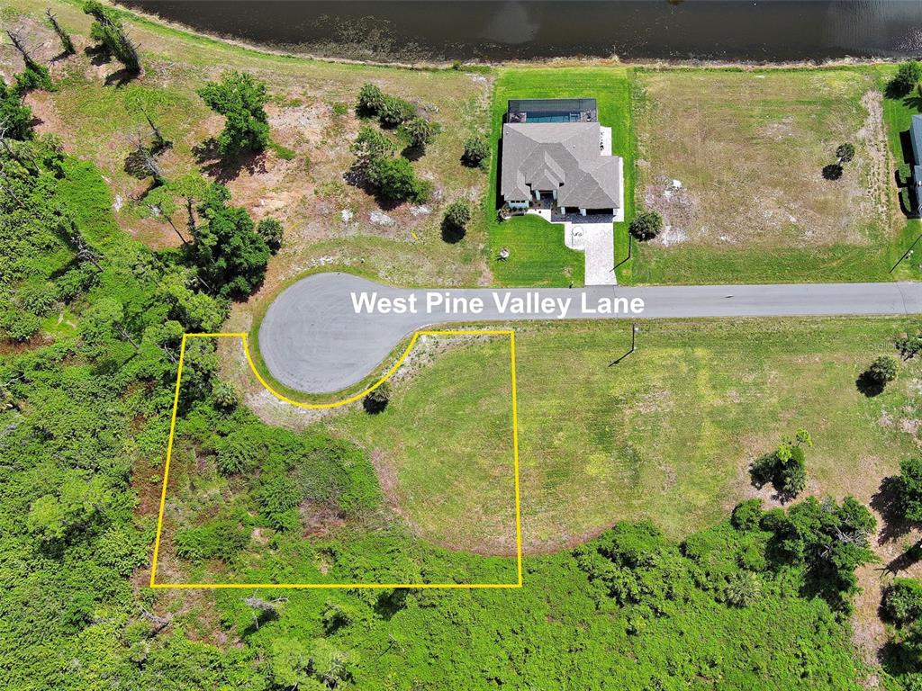 An aerial view shows a vacant, partially wooded residential lot outlined in yellow on a cul-de-sac — 171 W PINE VALLEY LANE, ROTONDA WEST, FL